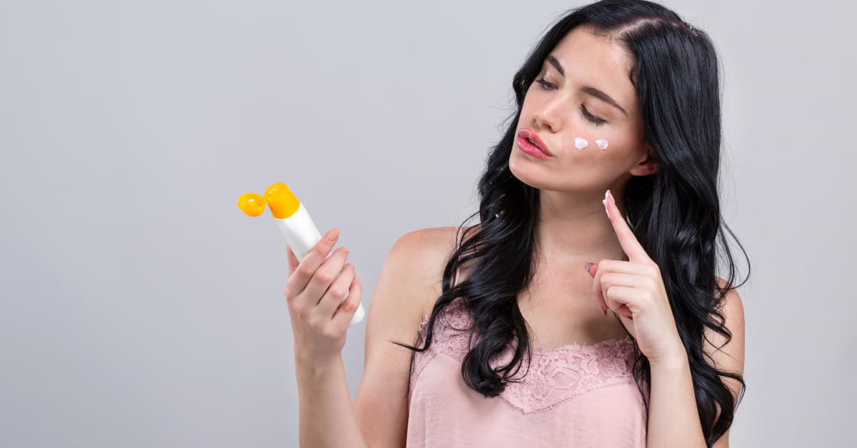 Mujer aplicando protector solar con maquillaje